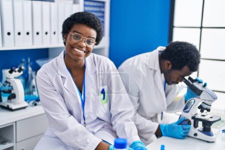 Téléchargez les photos : Des scientifiques afro-américains utilisent le microscope en laboratoire - en image libre de droit