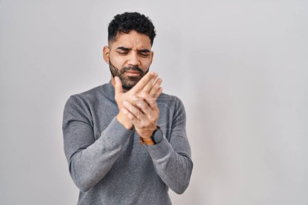 Foto de Hispanic man with beard standing over white background suffering pain on hands and fingers, arthritis inflammation - Imagen libre de derechos