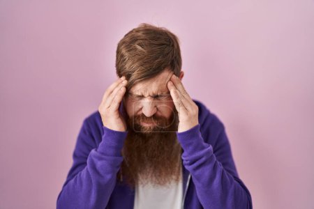 Photo for Caucasian man with long beard standing over pink background with hand on head for pain in head because stress. suffering migraine. - Royalty Free Image