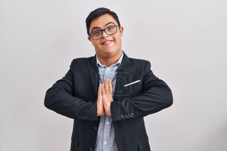 Photo for Young hispanic man with down syndrome wearing business style praying with hands together asking for forgiveness smiling confident. - Royalty Free Image