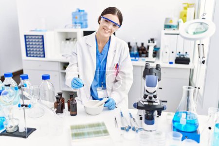 Photo for Young hispanic woman wearing scientist uniform working at laboratory - Royalty Free Image