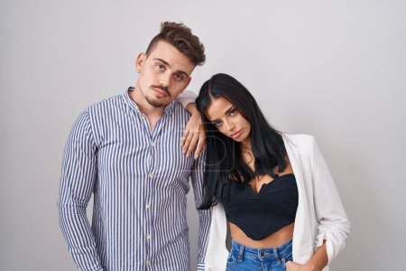 Photo for Young hispanic couple standing over white background looking sleepy and tired, exhausted for fatigue and hangover, lazy eyes in the morning. - Royalty Free Image