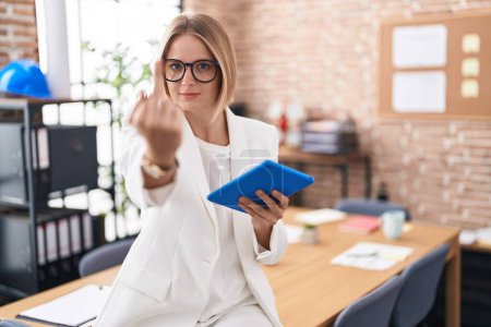 Foto de Young caucasian woman working at the office wearing glasses showing middle finger, impolite and rude fuck off expression - Imagen libre de derechos