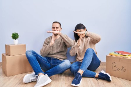 Photo for Young couple moving to a new home doing time out gesture with hands, frustrated and serious face - Royalty Free Image