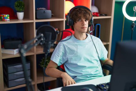Foto de Joven hombre rubio jugando videojuegos con computadora en la sala de juegos - Imagen libre de derechos