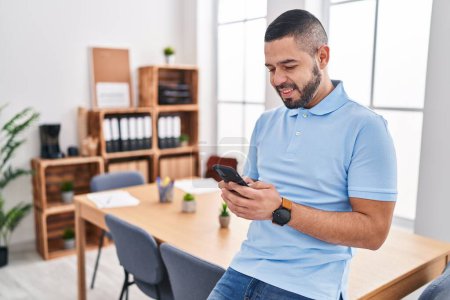 Téléchargez les photos : Young latin man business worker smiling confident using smartphone at office - en image libre de droit