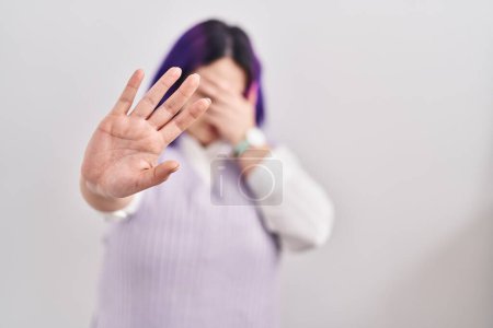 Téléchargez les photos : Plus size woman wit purple hair standing over white background covering eyes with hands and doing stop gesture with sad and fear expression. embarrassed and negative concept. - en image libre de droit