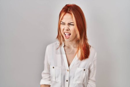 Téléchargez les photos : Young caucasian woman standing over isolated background angry and mad screaming frustrated and furious, shouting with anger. rage and aggressive concept. - en image libre de droit