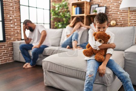 Familie sitzt auf Sofa und Kind traurig über Elternstreit zu Hause