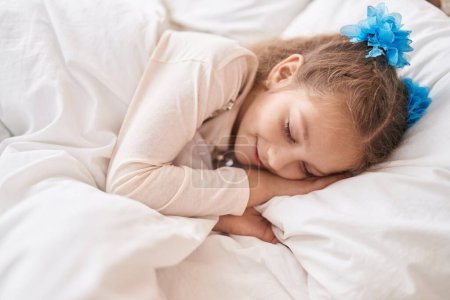 Foto de Adorable caucasian girl lying on bed sleeping at bedroom - Imagen libre de derechos