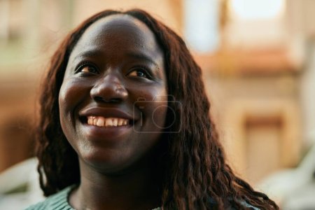 Foto de Joven mujer africana sonriendo feliz en la ciudad - Imagen libre de derechos
