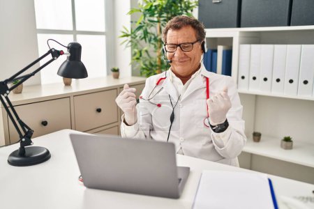 Photo for Senior doctor man working on online appointment doing money gesture with hands, asking for salary payment, millionaire business - Royalty Free Image