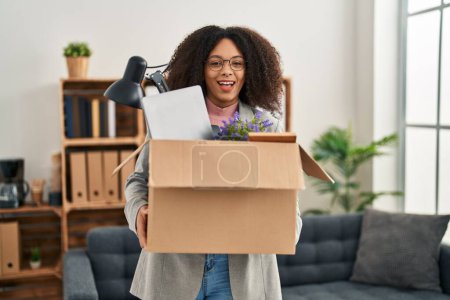 Photo for Young african american woman moving to a new office holding box with items smiling and laughing hard out loud because funny crazy joke. - Royalty Free Image