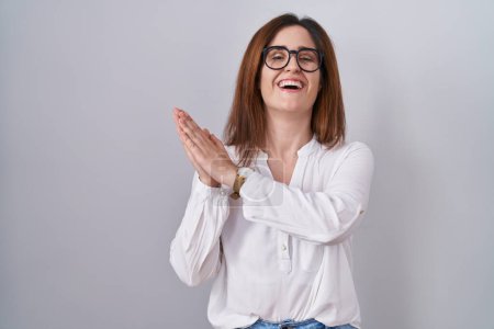 Téléchargez les photos : Brunette woman standing over white isolated background clapping and applauding happy and joyful, smiling proud hands together - en image libre de droit