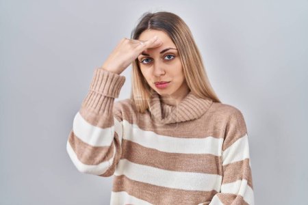 Photo for Young blonde woman wearing turtleneck sweater over isolated background worried and stressed about a problem with hand on forehead, nervous and anxious for crisis - Royalty Free Image