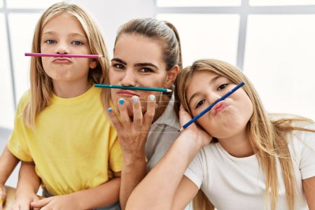 Photo for Mother and daughters with funny expression drawing at home - Royalty Free Image