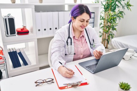 Photo for Young beautiful plus size woman doctor holding pills bottle writing on document at clinic - Royalty Free Image