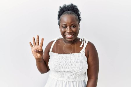 Téléchargez les photos : Jeune femme africaine debout sur fond blanc isolé montrant et pointant vers le haut avec les doigts numéro quatre tout en souriant confiant et heureux. - en image libre de droit