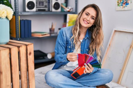 Photo for Young woman artist smiling confident choosing color at art studio - Royalty Free Image