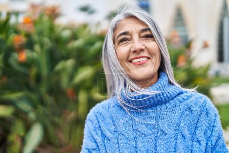 Téléchargez les photos : Femme aux cheveux gris d'âge moyen souriant debout avec confiance au parc - en image libre de droit