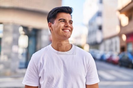 Foto de Young hispanic man smiling confident looking to the side at street - Imagen libre de derechos