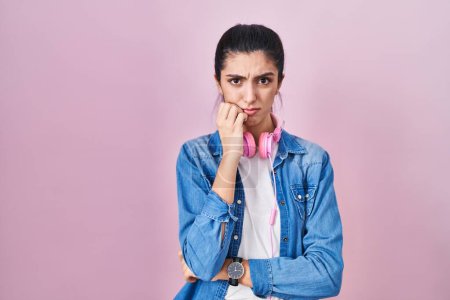 Photo for Young beautiful woman standing over pink background looking stressed and nervous with hands on mouth biting nails. anxiety problem. - Royalty Free Image