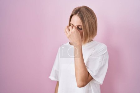 Téléchargez les photos : Jeune femme caucasienne debout sur fond rose fatigué se frottant le nez et les yeux ressentant fatigue et maux de tête. concept de stress et de frustration. - en image libre de droit