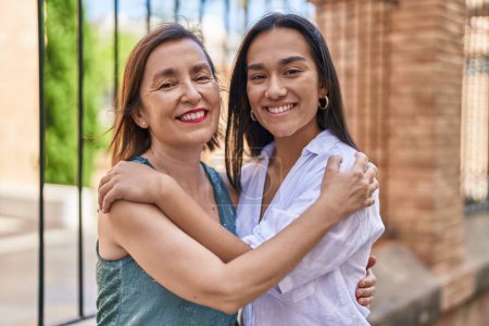 Téléchargez les photos : Two women mother and daughter smiling confident hugging each other at street - en image libre de droit