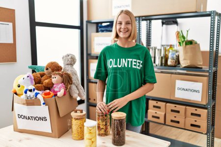 Photo for Young caucasian woman wearing volunteer t shirt at donations stand with a happy and cool smile on face. lucky person. - Royalty Free Image