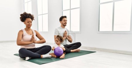 Foto de Couple and daughter smiling confident training yoga at sport center - Imagen libre de derechos
