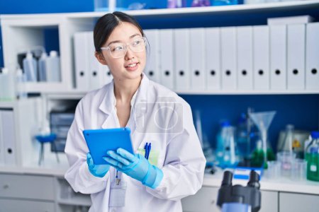 Photo for Chinese woman scientist using touchpad working at laboratory - Royalty Free Image