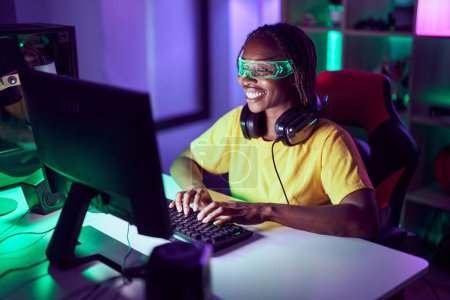 Téléchargez les photos : African american woman streamer jouer à un jeu vidéo en utilisant des lunettes de réalité virtuelle à la salle de jeux - en image libre de droit