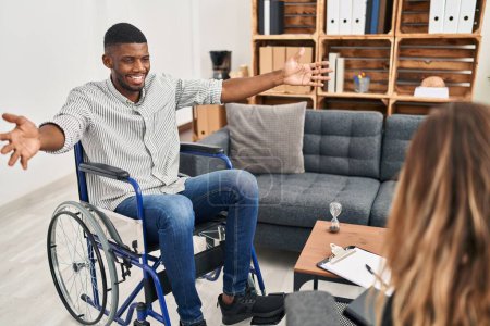 Téléchargez les photos : African american man doing therapy sitting on wheelchair looking at the camera smiling with open arms for hug. cheerful expression embracing happiness. - en image libre de droit