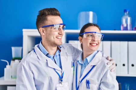 Téléchargez les photos : Man and woman scientists smiling confident hugging each other at laboratory - en image libre de droit