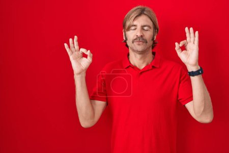 Photo for Caucasian man with mustache standing over red background relax and smiling with eyes closed doing meditation gesture with fingers. yoga concept. - Royalty Free Image