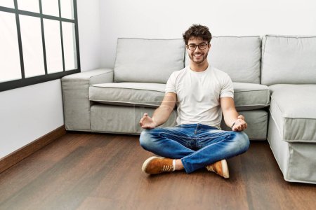 Photo for Young hispanic man smiling confident doing yoga exercise at home - Royalty Free Image