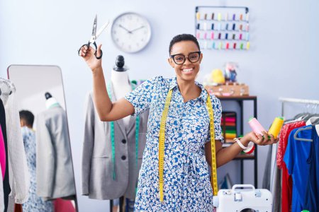 Photo for African american woman tailor smiling confident holding scissors and thread at tailor shop - Royalty Free Image