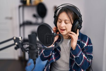 Foto de Mujer joven con síndrome de Down músico cantando canción en el estudio de música - Imagen libre de derechos