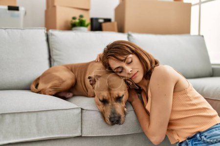 Photo for Young caucasian woman sleeping sitting on floor with dog at home - Royalty Free Image