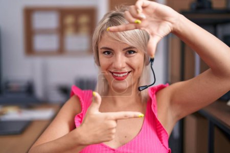 Photo for Young caucasian woman wearing call center agent headset smiling making frame with hands and fingers with happy face. creativity and photography concept. - Royalty Free Image