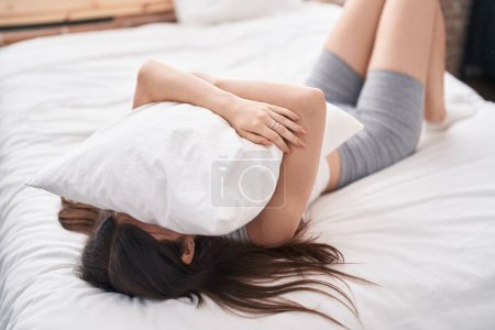 Téléchargez les photos : Jeune femme caucasienne couchée sur le lit pleurant dans la chambre - en image libre de droit
