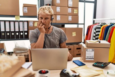 Téléchargez les photos : Young blond man wearing operator headset working at online shop looking stressed and nervous with hands on mouth biting nails. anxiety problem. - en image libre de droit