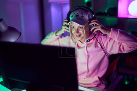 Photo for Young blonde woman streamer using computer and headphones at gaming room - Royalty Free Image