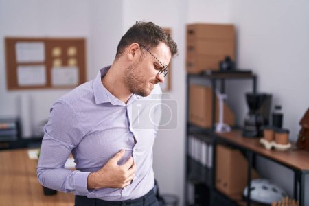 Téléchargez les photos : Jeune homme hispanique au bureau souffrant de douleurs au cou, touchant le cou avec la main, douleurs musculaires - en image libre de droit