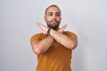 Photo for Hispanic man with beard standing over white background rejection expression crossing arms doing negative sign, angry face - Royalty Free Image