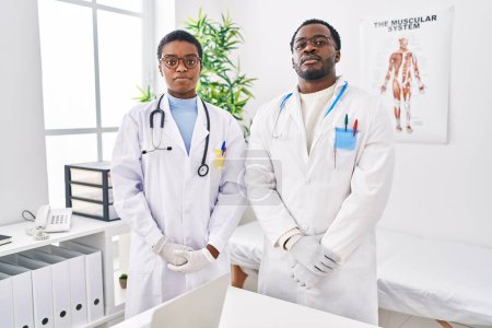 Foto de Jóvenes médicos afroamericanos que trabajan en la clínica médica con expresión seria en la cara. simple y natural mirando a la cámara. - Imagen libre de derechos
