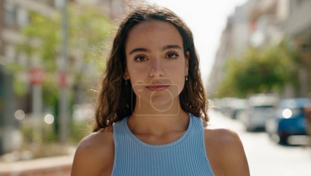 Photo for Young beautiful hispanic woman standing with serious expression at street - Royalty Free Image