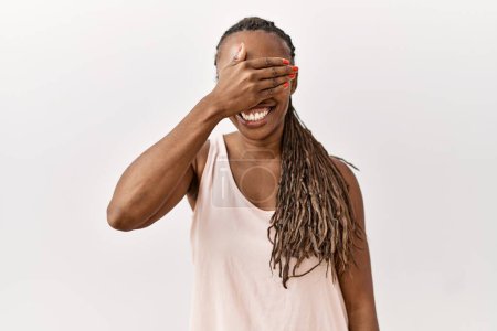 Photo for Black woman with braids standing over isolated background smiling and laughing with hand on face covering eyes for surprise. blind concept. - Royalty Free Image