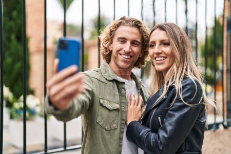 Foto de Hombre y mujer pareja sonriendo confiado hacer selfie por el teléfono inteligente en la calle - Imagen libre de derechos