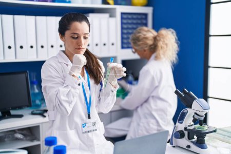 Photo for Young hispanic woman working at scientist laboratory serious face thinking about question with hand on chin, thoughtful about confusing idea - Royalty Free Image